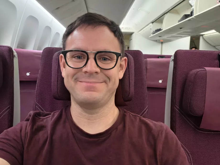 Jag på Qatar Airways (min T-shirt matchar färgskalan i kabinen!)