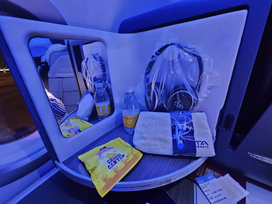 Öppningspanel med spegel, hörlurar, kex och vatten