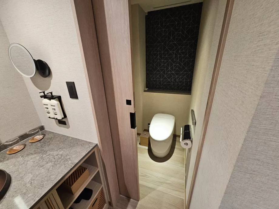 Separerad toalett från resten av badrummet med en dörr