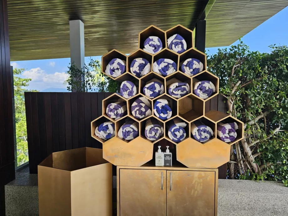 Handdukar och solskyddsmedel vid poolen